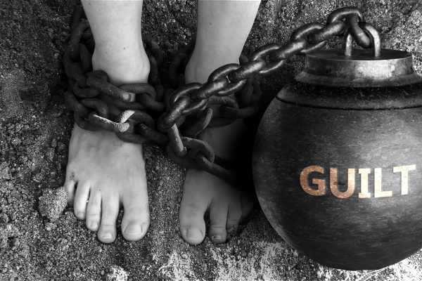 foot attached to a ball and chain labeled guilt